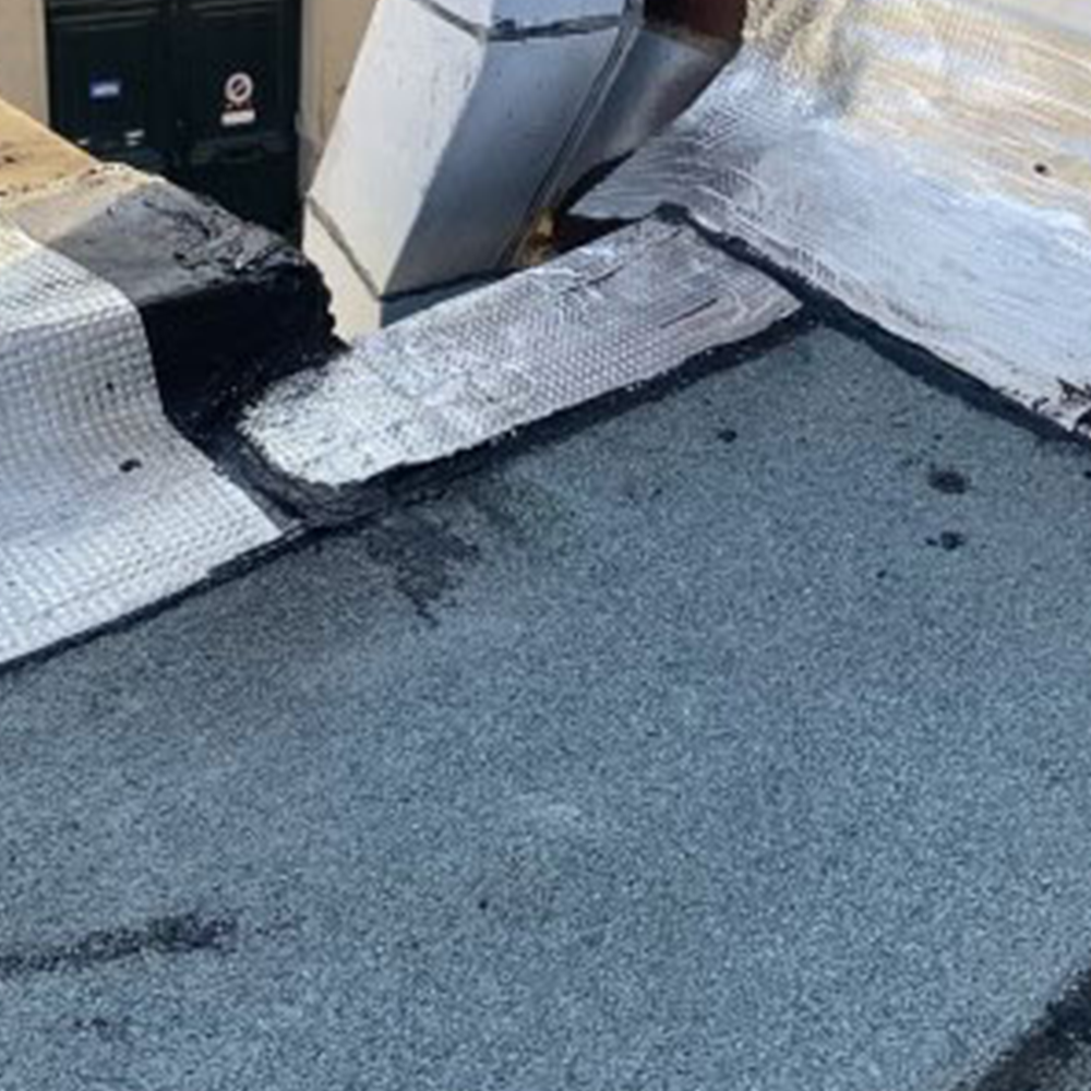 Chantier de toit avec pose de rouleaux bitume