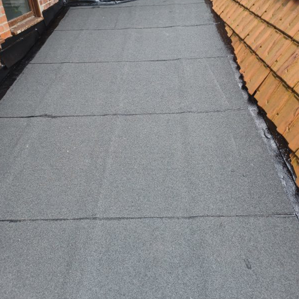 Chantier pose de rouleaux bitume sur un toit